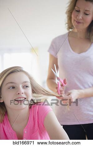 Caucasian mother cutting hair of daughter View Large Photo Image Stock Image - Caucasian mother cutting hair of daughter. Fotosearch