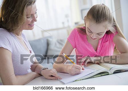 Stock Photograph - Caucasian mother helping daughter with homework. Fotosearch