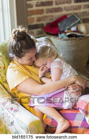 Caucasian mother holding daughter in armchair View Large Photo Image Stock Photography - Caucasian mother holding daughter in armchair. Fotosearch