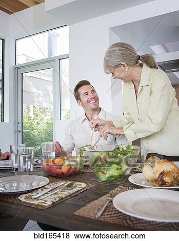 Caucasian mother serving son at table View Large Photo Image Stock Photo - Caucasian mother serving son at table. Fotosearch