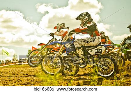 Stock Photography - Caucasian motocross bikers riding on race course. Fotosearch