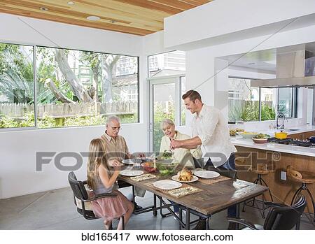 Caucasian multi-generation family eating at table View Large Photo Image Stock Photo - Caucasian multi-generation family eating at table. Fotosearch