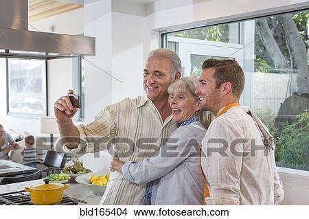 Caucasian parents and son taking selfie in kitchen View Large Photo Image Picture - Caucasian parents and son taking selfie in kitchen. Fotosearch