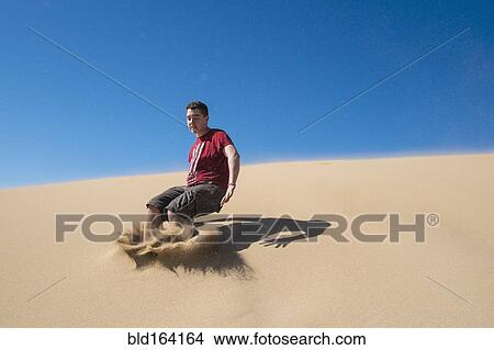Caucasian teenage boy jumping on sand dune View Large Photo Image Picture - Caucasian teenage boy jumping on sand dune. Fotosearch