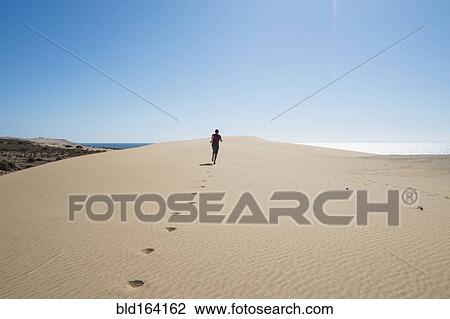 Caucasian teenage boy running on sand dune View Large Photo Image Stock Image - Caucasian teenage boy running on sand dune. Fotosearch