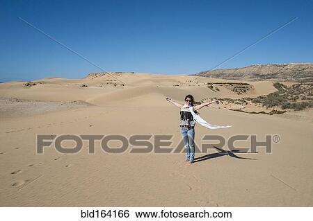 Caucasian woman cheering on sand dune View Large Photo Image Stock Photograph - Caucasian woman cheering on sand dune. Fotosearch