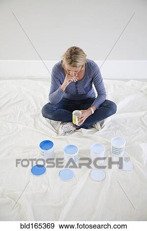 Caucasian woman examining paint samples in new home View Large Photo Image Stock Photo - Caucasian woman examining paint samples in new home. Fotosearch