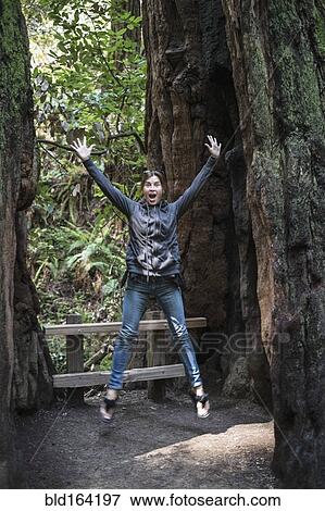 Caucasian woman jumping for joy in forest View Large Photo Image Stock Photo - Caucasian woman jumping for joy in forest. Fotosearch