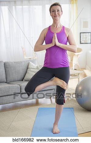 Caucasian woman practicing yoga in living room View Large Photo Image Stock Image - Caucasian woman practicing yoga in living room. Fotosearch