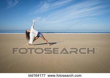 Caucasian woman practicing yoga on beach View Large Photo Image Stock Photo - Caucasian woman practicing yoga on beach. Fotosearch