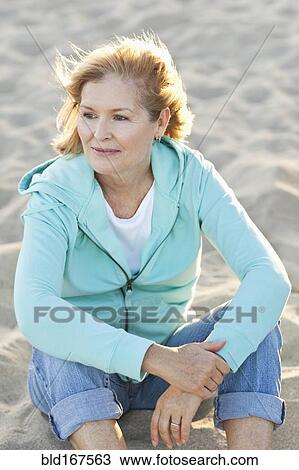 Caucasian woman sitting on beach View Large Photo Image Stock Image - Caucasian woman sitting on beach. Fotosearch