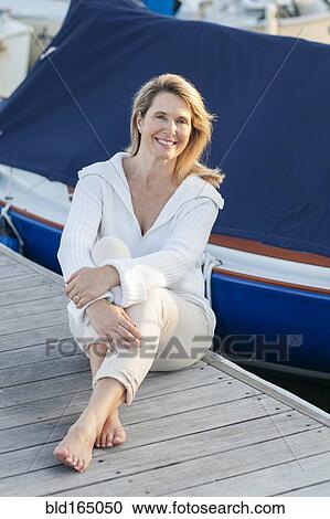 Caucasian woman sitting on deck in harbor View Large Photo Image Stock Image - Caucasian woman sitting on deck in harbor. Fotosearch