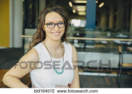 Stock Image - Caucasian woman smiling in cafe. Fotosearch