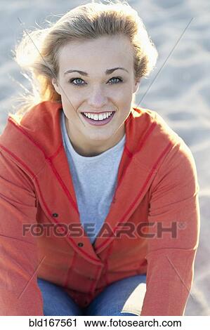 Stock Image - Caucasian woman smiling on beach. Fotosearch