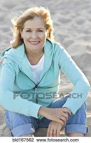 Stock Image - Caucasian woman smiling on beach. Fotosearch