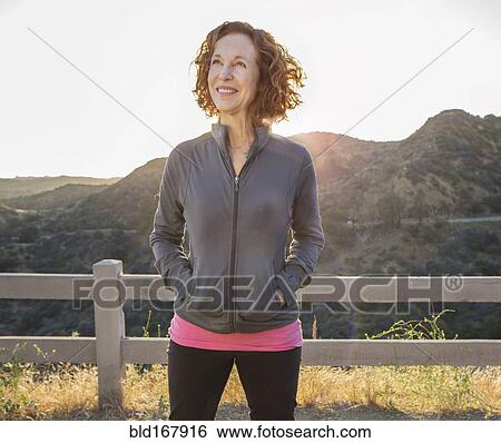 Stock Photograph - Caucasian woman smiling on hilltop. Fotosearch