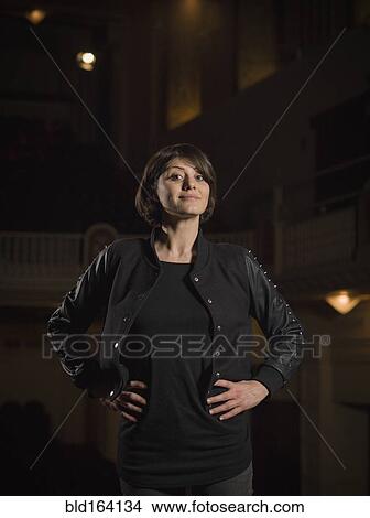 Picture - Caucasian woman standing in movie theater. Fotosearch