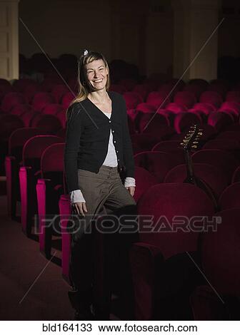Caucasian woman standing in movie theater View Large Photo Image Stock Image - Caucasian woman standing in movie theater. Fotosearch
