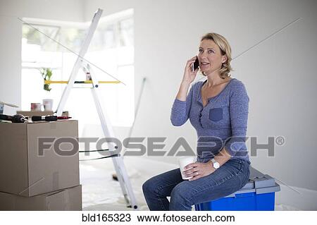 Caucasian woman talking on cell phone in new home View Large Photo Image Stock Image - Caucasian woman talking on cell phone in new home. Fotosearch