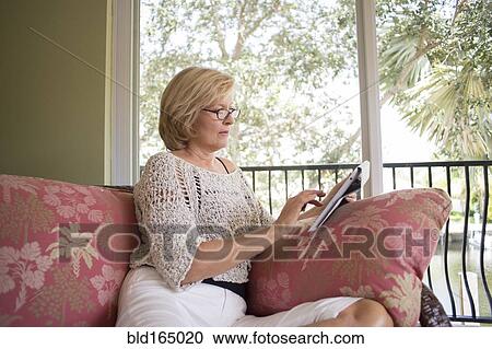 Caucasian woman using digital tablet on sofa View Large Photo Image Stock Image - Caucasian woman using digital tablet on sofa. Fotosearch