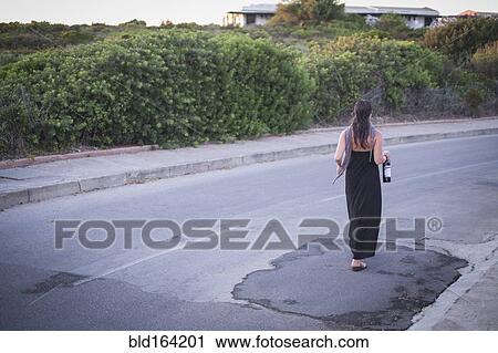 Caucasian woman walking on empty road View Large Photo Image Stock Image - Caucasian woman walking on empty road. Fotosearch