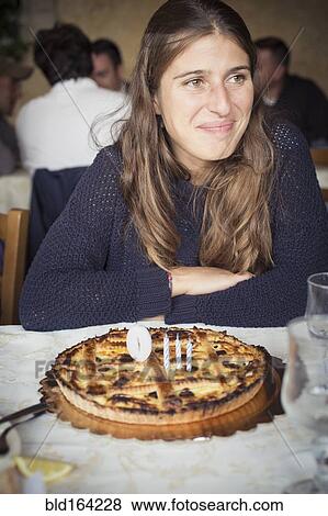 Stock Photo - Caucasian woman with birthday cake in restaurant. Fotosearch