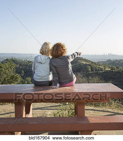 Picture - Caucasian women admiring scenic view from hilltop. Fotosearch