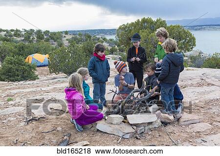 Stock Photo - Children building campfire on field trip. Fotosearch
