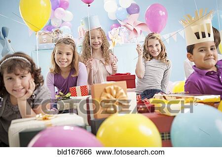 Stock Photograph - Children smiling at birthday party. Fotosearch