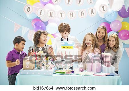 Children smiling near cake and gifts at birthday party View Large Photo Image Picture - Children smiling near cake and gifts at birthday party. Fotosearch
