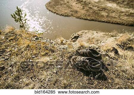 Close up of abandoned shoes over remote river View Large Photo Image Stock Photography - Close up of abandoned shoes over remote river. Fotosearch