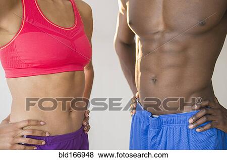 Close up of abdominals of athletic couple wearing sportswear View Large Photo Image Stock Photo - Close up of abdominals of athletic couple wearing sportswear. Fotosearch