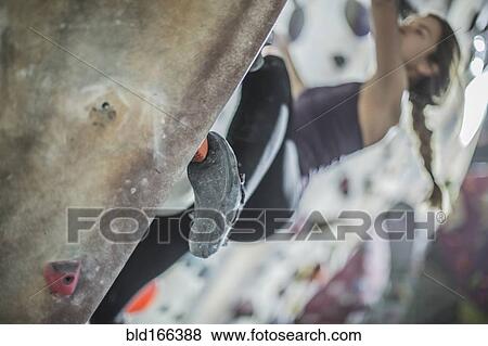 Close up of athlete climbing rock wall in gym View Large Photo Image Stock Photo - Close up of athlete climbing rock wall in gym. Fotosearch