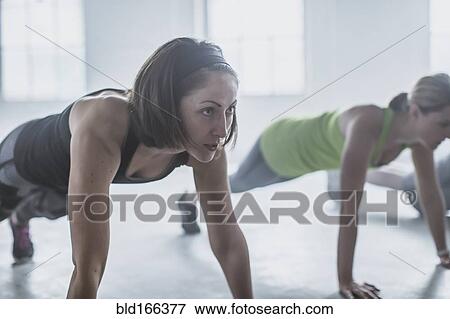 Stock Photo - Close up of athlete doing push-ups in gym. Fotosearch