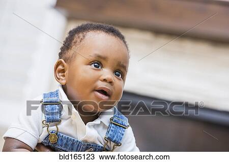 Stock Image - Close up of Black baby boy in living room. Fotosearch