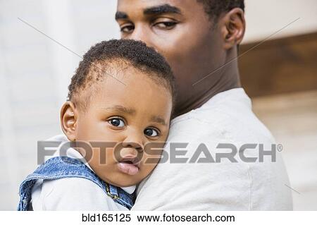 Close up of Black father holding baby son View Large Photo Image Stock Photography - Close up of Black father holding baby son. Fotosearch