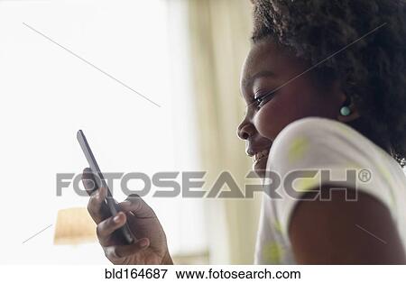 Close up of Black girl using cell phone View Large Photo Image Stock Photo - Close up of Black girl using cell phone. Fotosearch