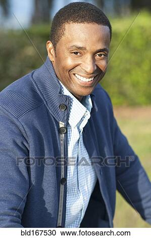 Stock Image - Close up of Black man smiling outdoors. Fotosearch