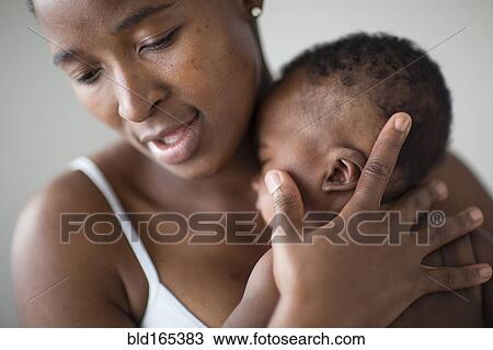 Stock Image - Close up of Black mother comforting baby. Fotosearch