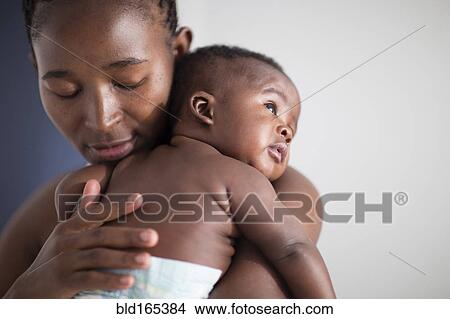 Picture - Close up of Black mother holding baby. Fotosearch