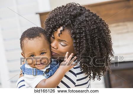 Stock Photograph - Close up of Black mother holding baby son. Fotosearch