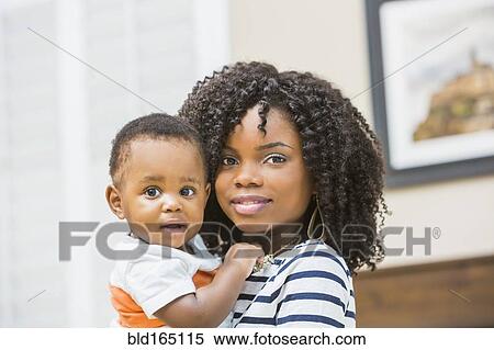 Close up of Black mother holding baby son View Large Photo Image Stock Photography - Close up of Black mother holding baby son. Fotosearch