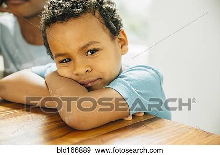 Stock Photo - Close up of boy leaning on table. Fotosearch