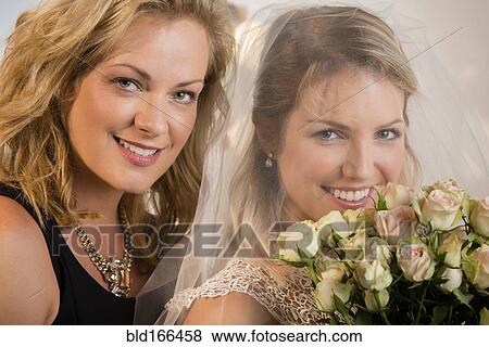 Stock Photo - Close up of bride and maid of honor smiling. Fotosearch