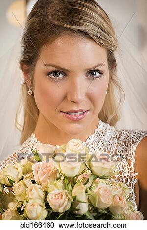 Stock Image - Close up of bride holding bouquet of flowers. Fotosearch