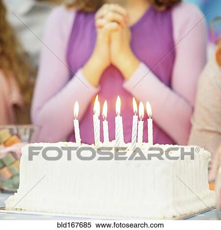 Stock Photography - Close up of candles on birthday cake at party. Fotosearch