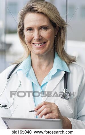 Stock Image - Close up of Caucasian doctor using digital tablet. Fotosearch