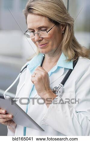 Stock Image - Close up of Caucasian doctor using digital tablet. Fotosearch