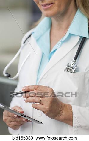 Stock Photo - Close up of Caucasian doctor using digital tablet. Fotosearch