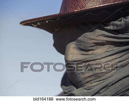 Stock Photo - Close up of Caucasian traveler wearing face scarf. Fotosearch